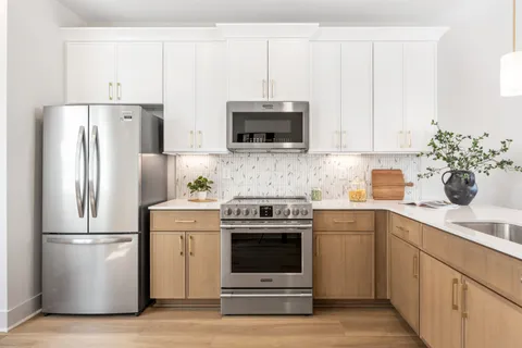 a kitchen with refrigerator a microwave a stove and cabinets