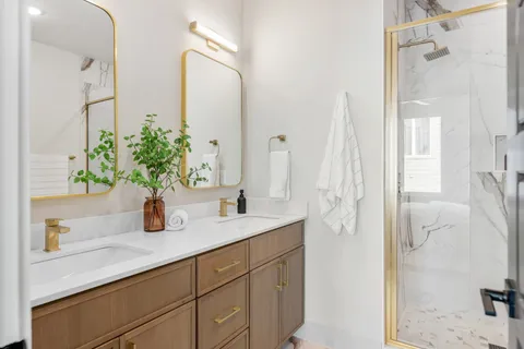 a bathroom with a granite countertop sink a mirror and a shower