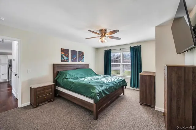 a bed sitting in a room with a flat screen tv and dresser