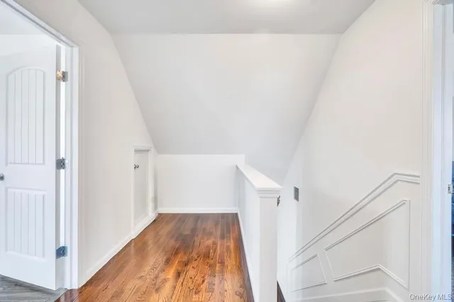 a view of a hallway with white walls and wooden floor