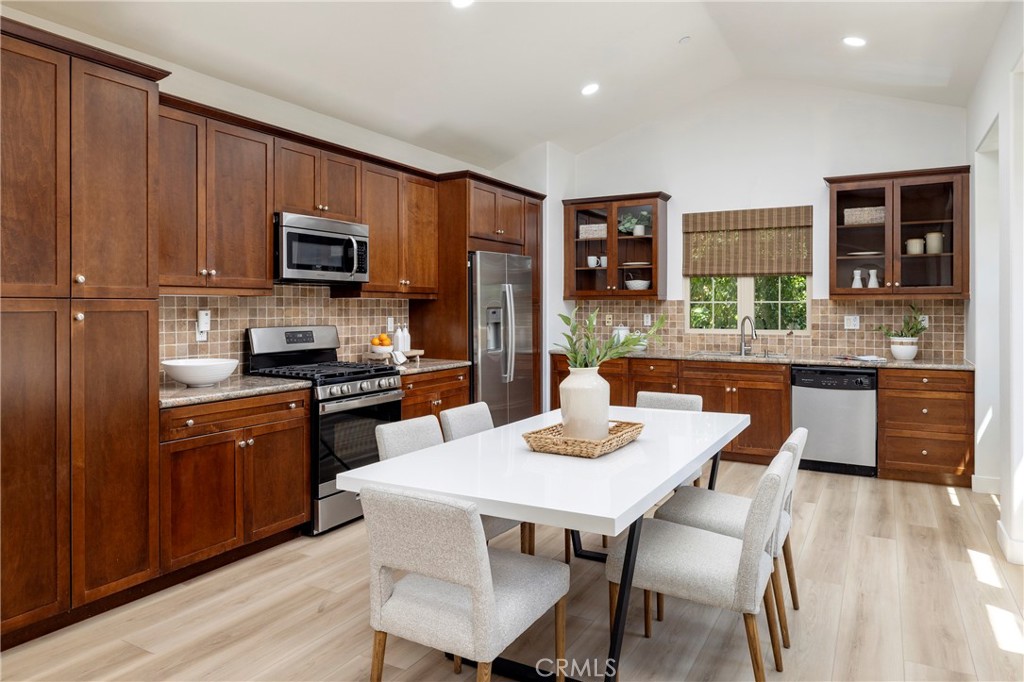 74 Townsend Irvine, CA 92620 - Photo 13 of 31 a kitchen with stainless steel appliances granite countertop a kitchen island hardwood floor sink stove dining table and chairs