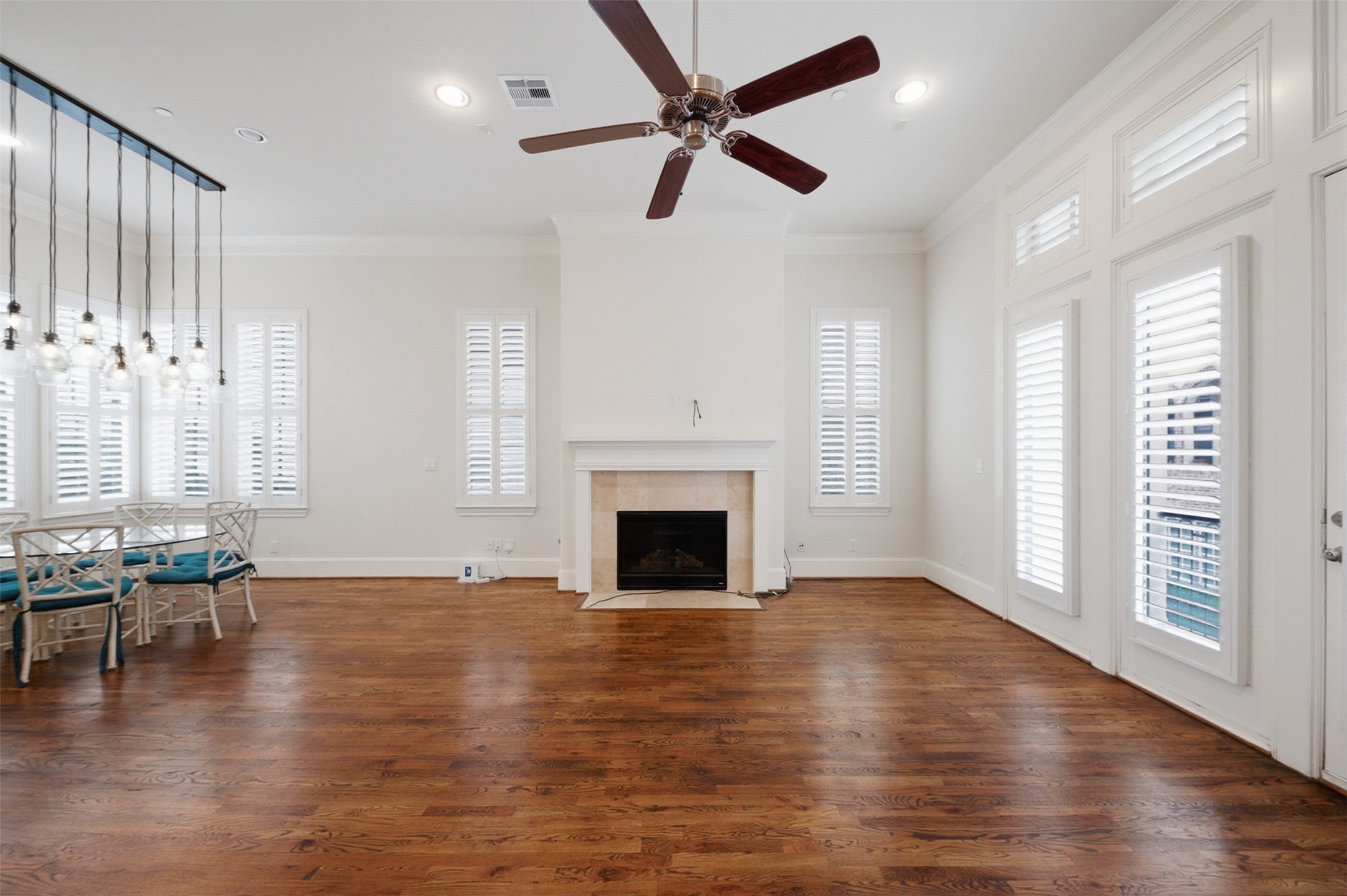 5606 Cohn Terrace Houston, TX 77007 - Photo 12 of 39 an empty room with wooden floor fireplace and windows