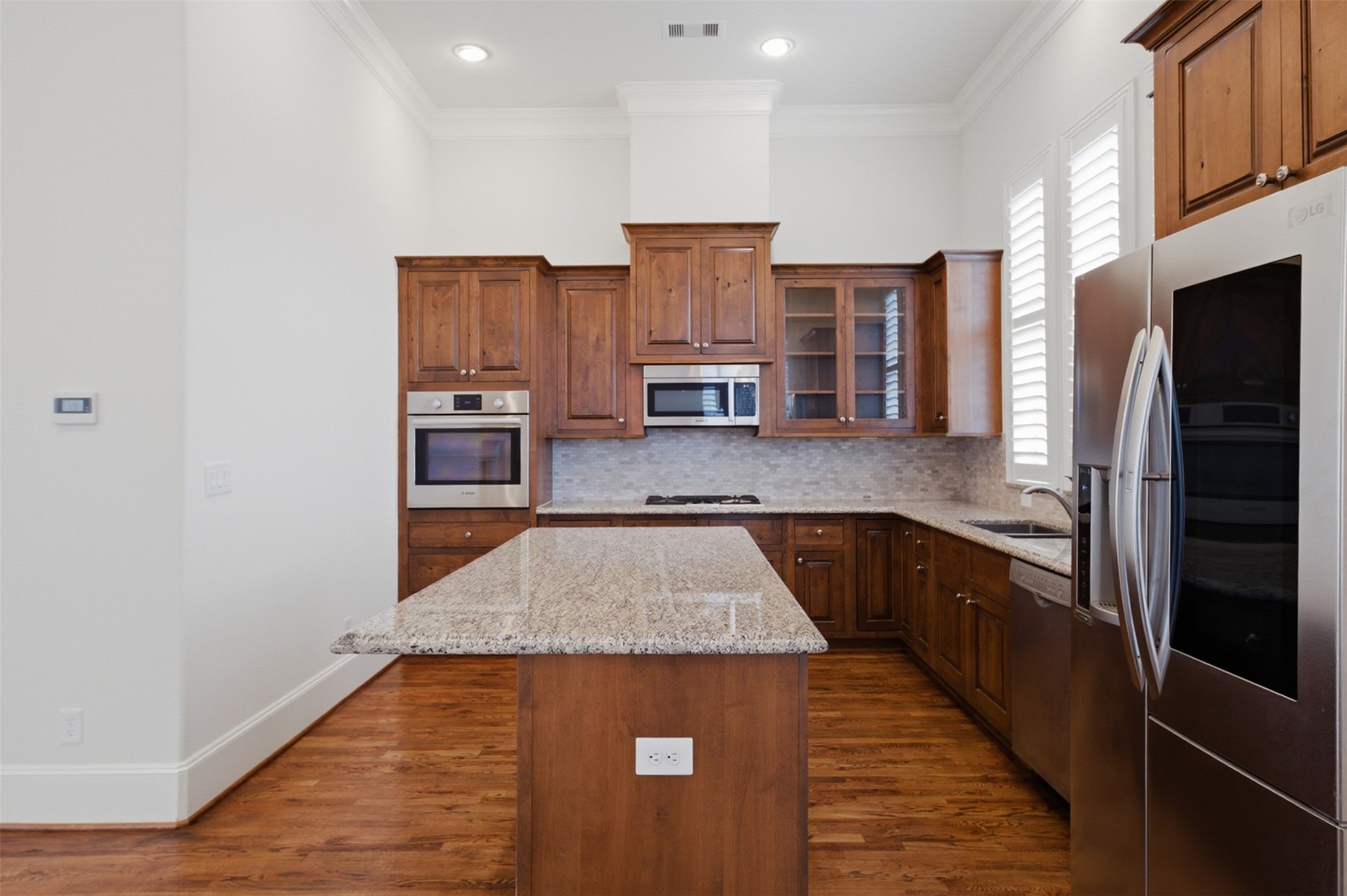 5606 Cohn Terrace Houston, TX 77007 - Photo 16 of 39 a kitchen with stainless steel appliances granite countertop a refrigerator a stove and a sink with wooden floors