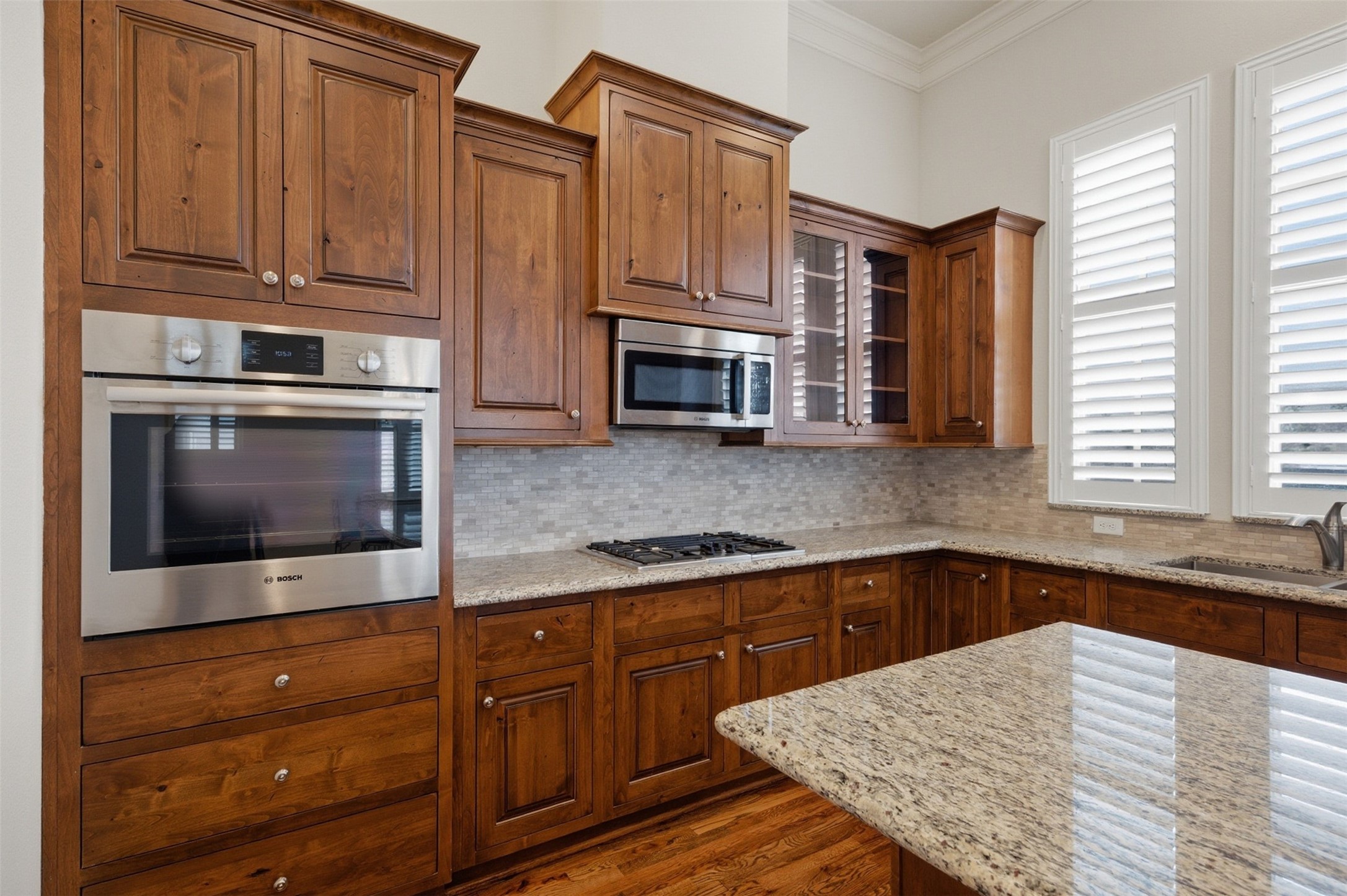 5606 Cohn Terrace Houston, TX 77007 - Photo 17 of 39 a kitchen with granite countertop wooden cabinets stainless steel appliances and a window