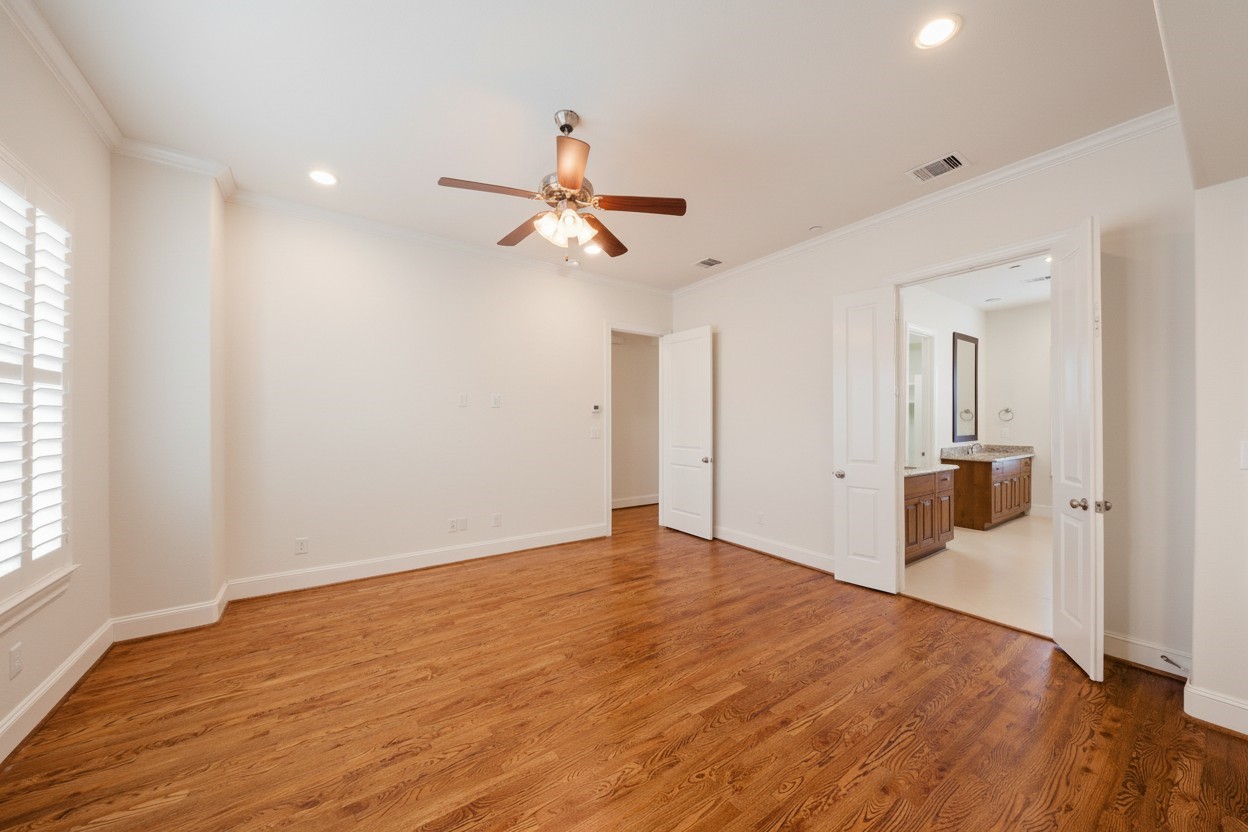 5606 Cohn Terrace Houston, TX 77007 - Photo 22 of 39 a view of a big room with wooden floor a ceiling fan and windows