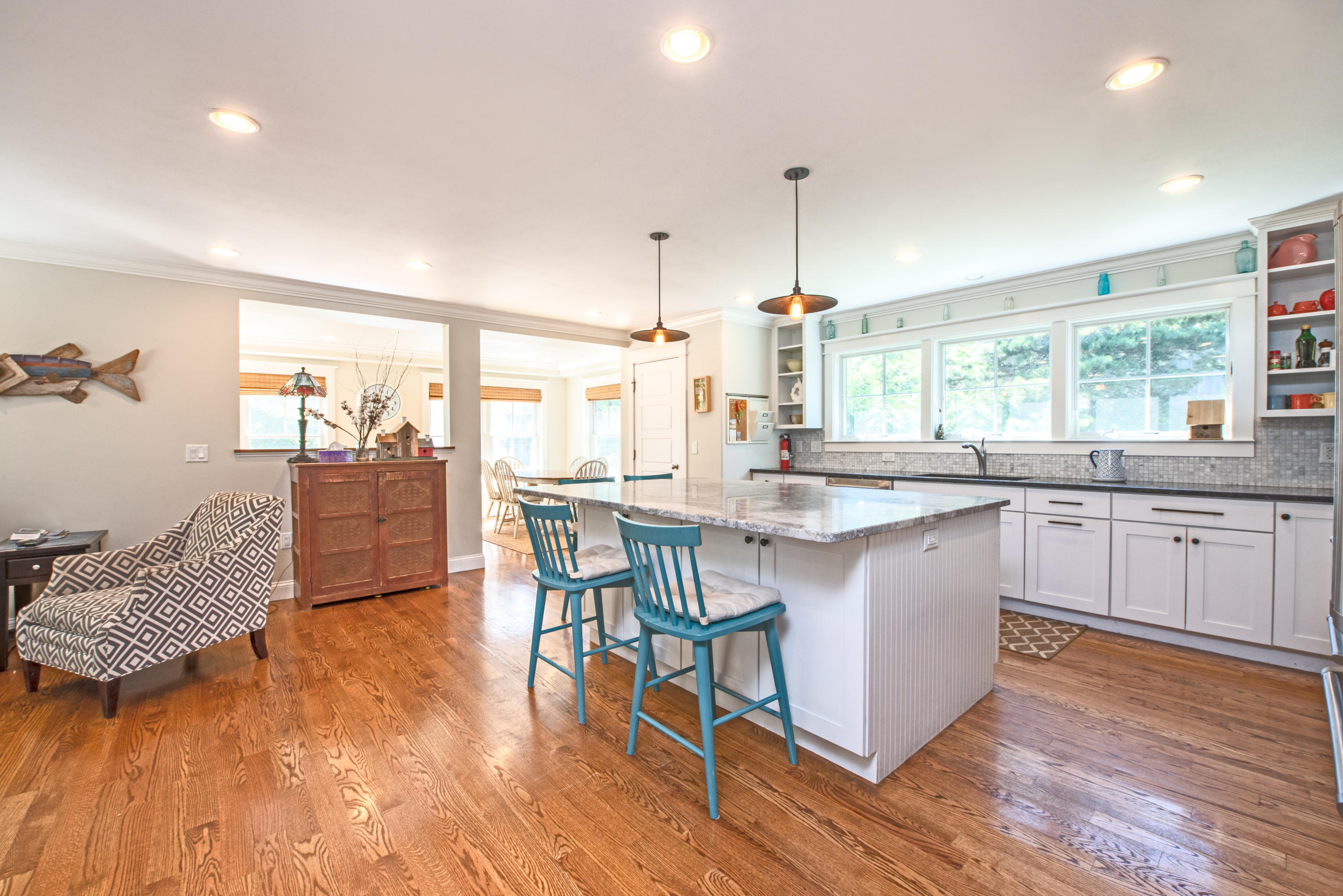 100 Peace Valley Road Wellfleet, MA 02667 - Photo 11 of 33 a kitchen with stainless steel appliances granite countertop a stove a sink dishwasher a dining table and chairs with wooden floor