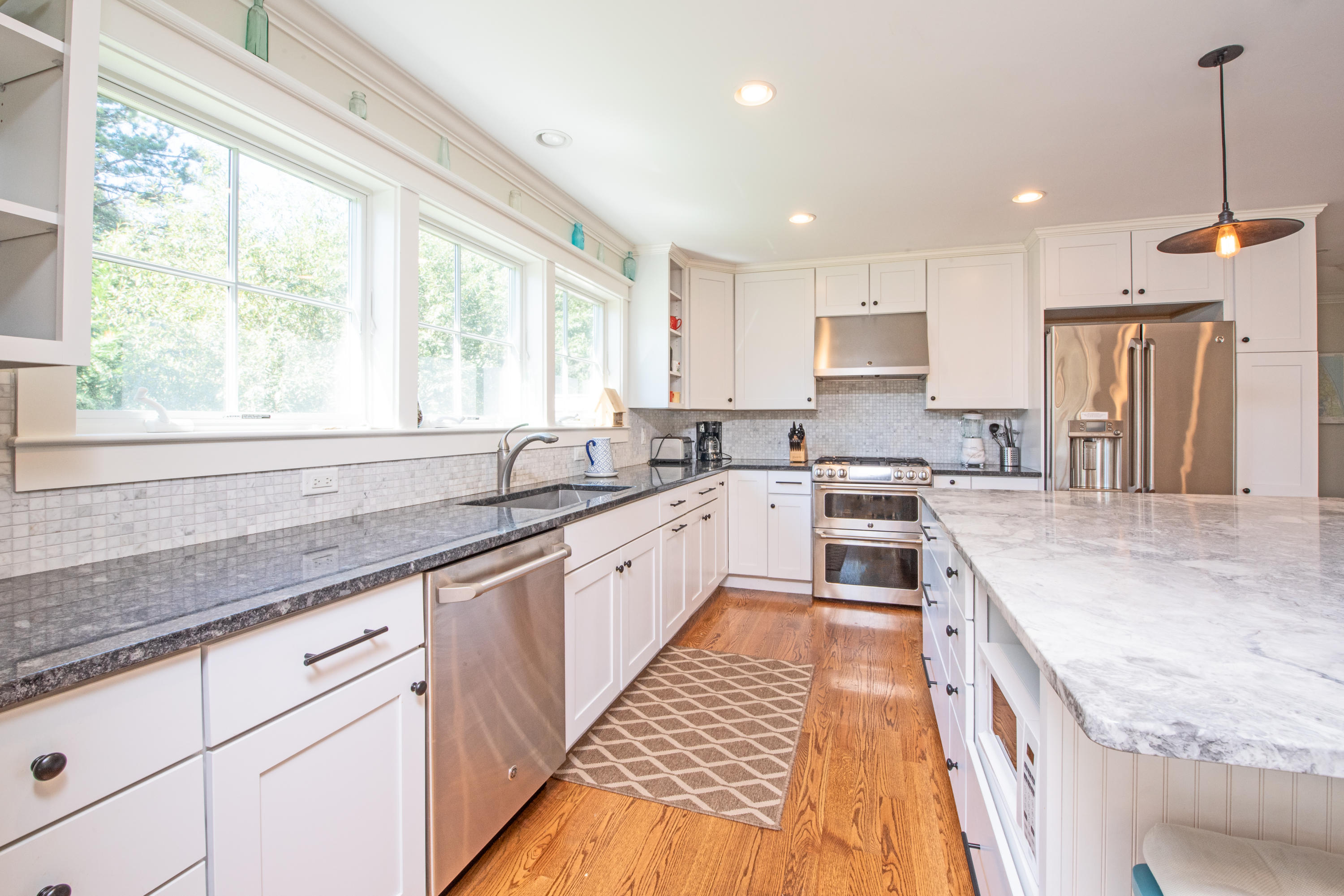 100 Peace Valley Road Wellfleet, MA 02667 - Photo 13 of 33 a large kitchen with granite countertop a large window and white cabinets