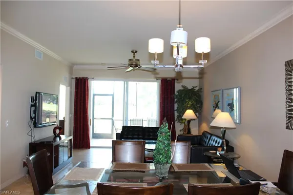 a dining room with wooden floor a chandelier a wooden table and chairs