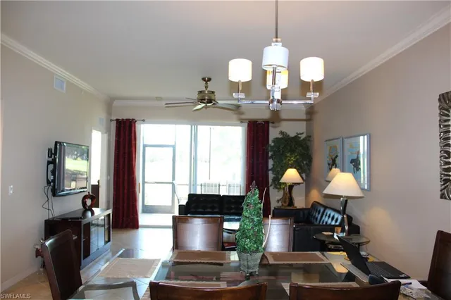 a dining room with wooden floor a chandelier a wooden table and chairs
