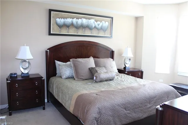 a bedroom with a bed and a lamp on dresser