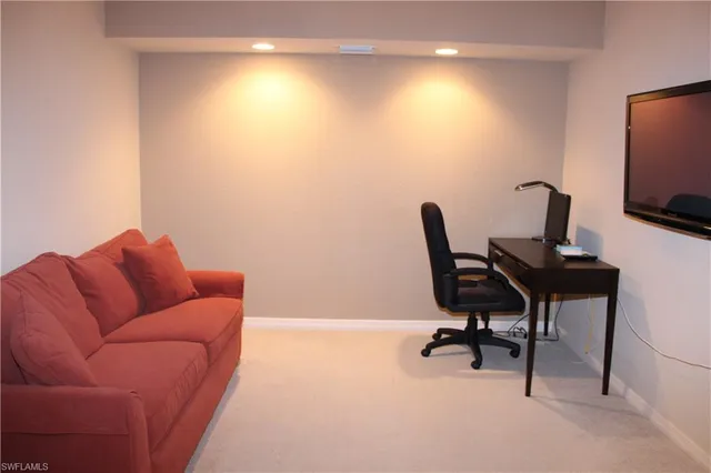 a work room with furniture and a flat screen tv