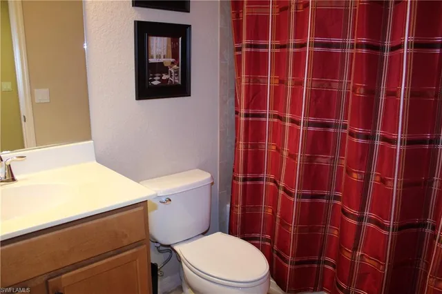 a bathroom with a toilet and a shower curtain