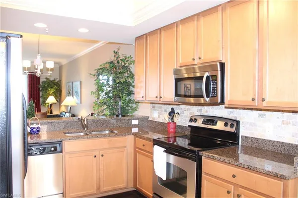 a kitchen with stainless steel appliances granite countertop a sink stove and microwave