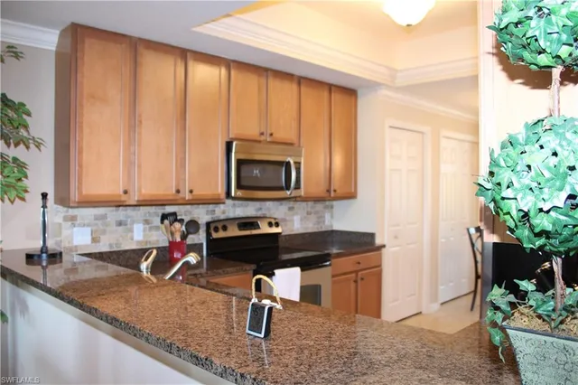a kitchen with stainless steel appliances granite countertop a sink a stove and a microwave