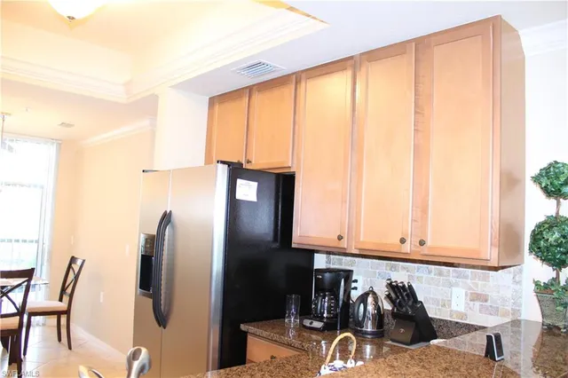 a kitchen with stainless steel appliances granite countertop a refrigerator and a window