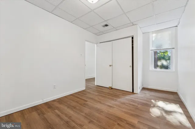 an empty room with windows and closet