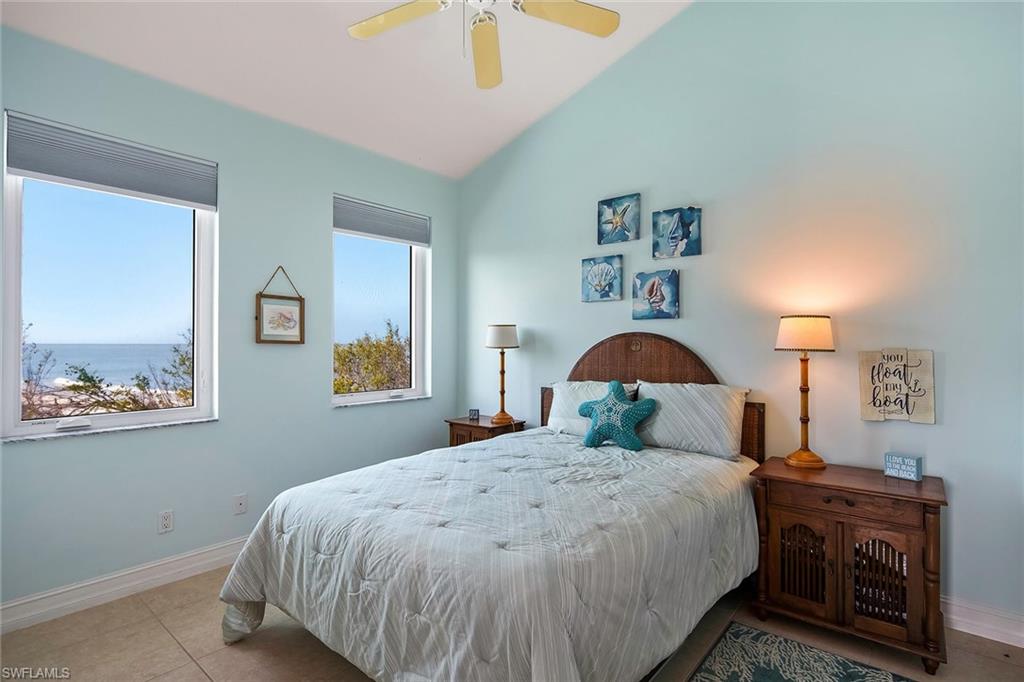 11687 Keewaydin Naples, FL 34113 - Photo 26 of 49 a bedroom with a large bed and a chandelier