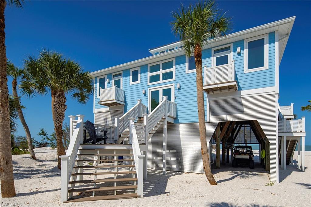 11687 Keewaydin Naples, FL 34113 - Photo 3 of 49 a front view of a house with garden