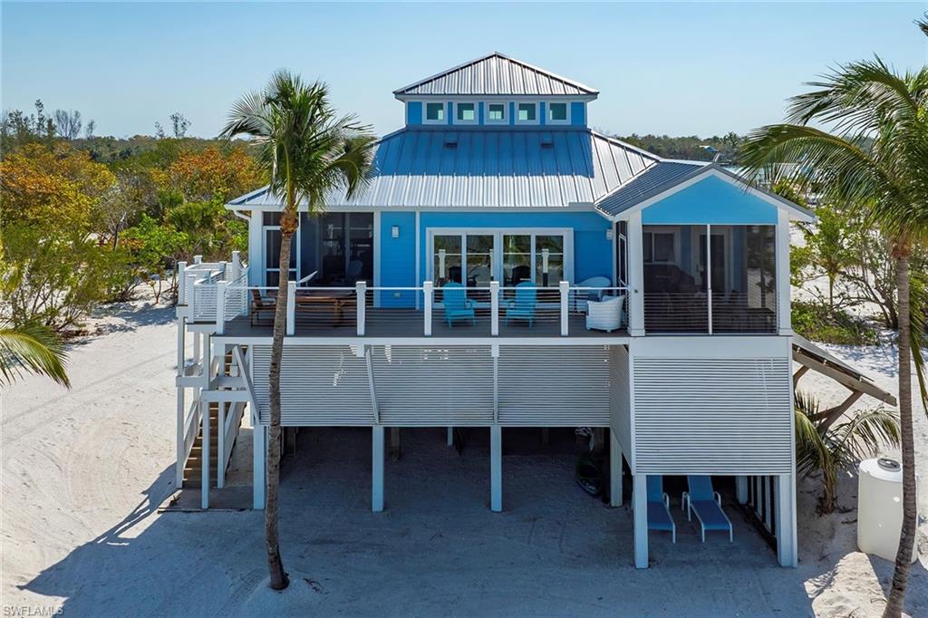 11687 Keewaydin Naples, FL 34113 - Photo 4 of 49 a front view of a house with a yard and balcony