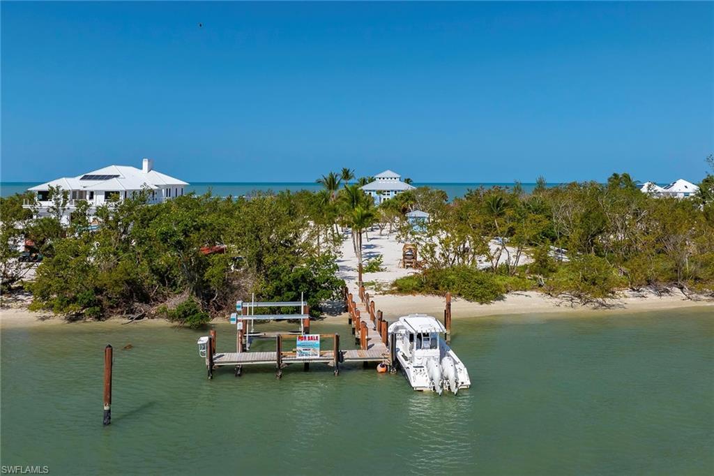 11687 Keewaydin Naples, FL 34113 - Photo 45 of 49 a view of a lake with a house in the background