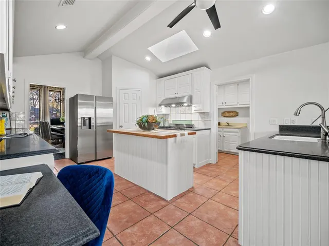 a kitchen with stainless steel appliances kitchen island granite countertop a refrigerator and a stove top oven