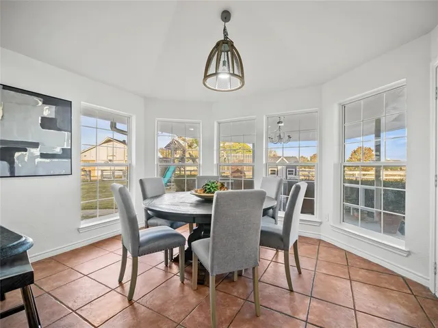 a dining room with furniture a rug and a large window