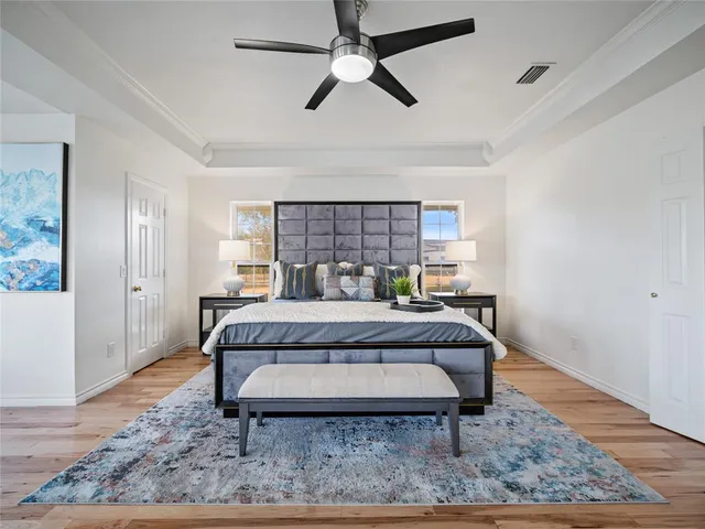 a bed sitting in a spacious bedroom next to a window