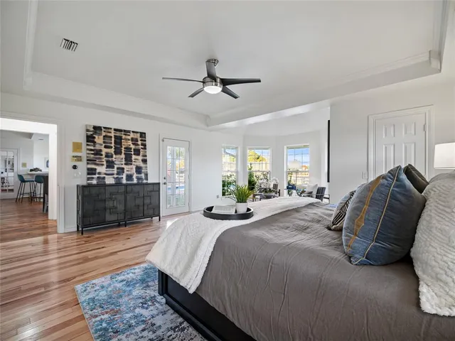 a bed sitting in a spacious bedroom next to a window and a kitchen