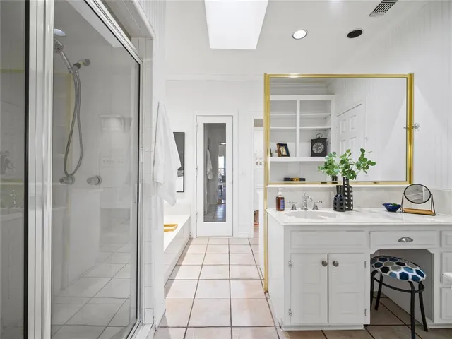 a bathroom with a double vanity sink a toilet and shower