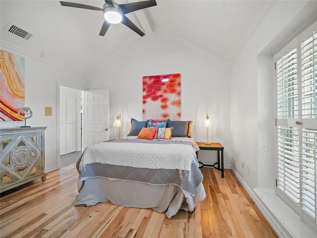 a bedroom with a bed and wooden floor
