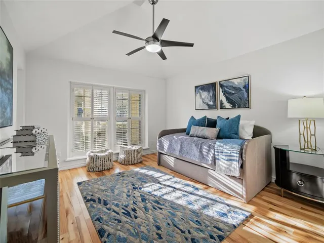 a bedroom with a bed a couch and large window