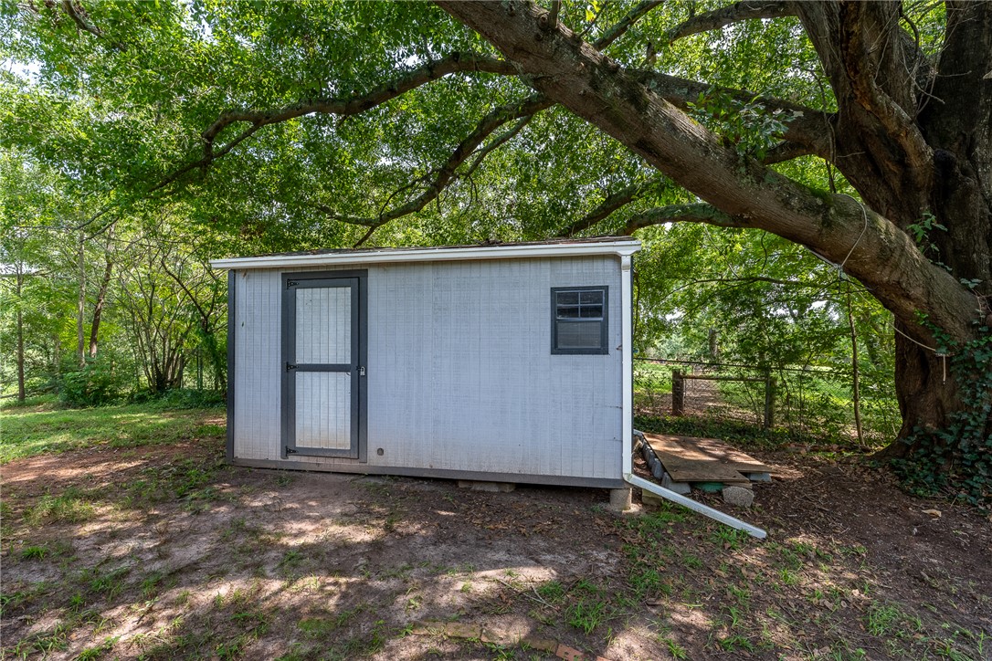 203 Muller Road Walhalla, SC 29691 - Photo 22 of 34 Mature trees shade a practical storage shed tucked away in the backyard.