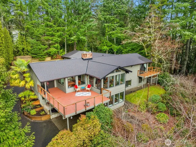 an aerial view of a house with swimming pool and large trees