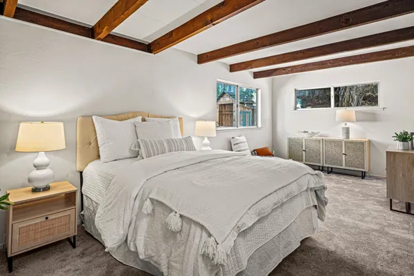 a spacious bedroom with a bed and wooden floor