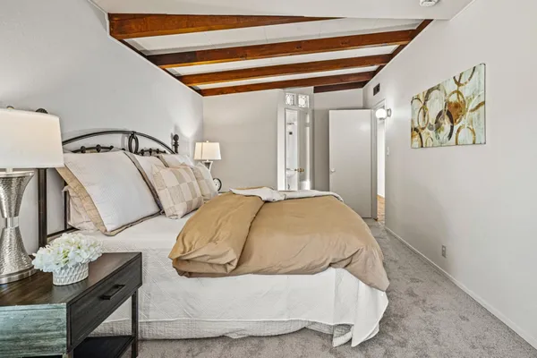 a bedroom with a bed and painting on the wall