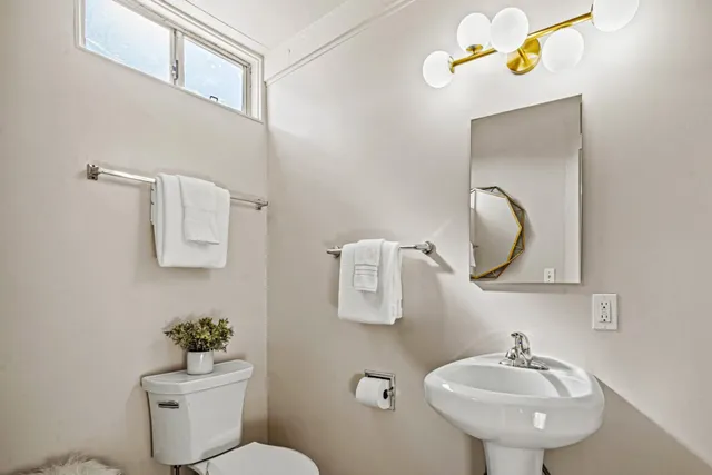 a bathroom with a toilet a sink and mirror