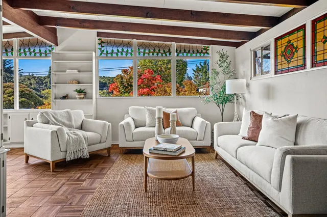 a living room with furniture and a painting on the wall