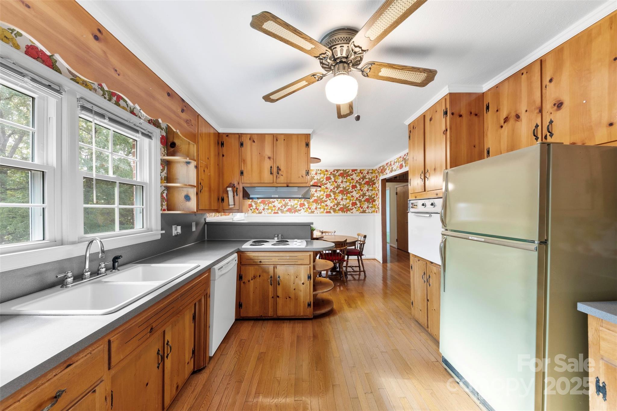 458 Roy Eaker Road Cherryville, NC 28021 - Photo 16 of 33 a kitchen with stainless steel appliances a refrigerator a sink dishwasher a stove and a dining table with wooden floor