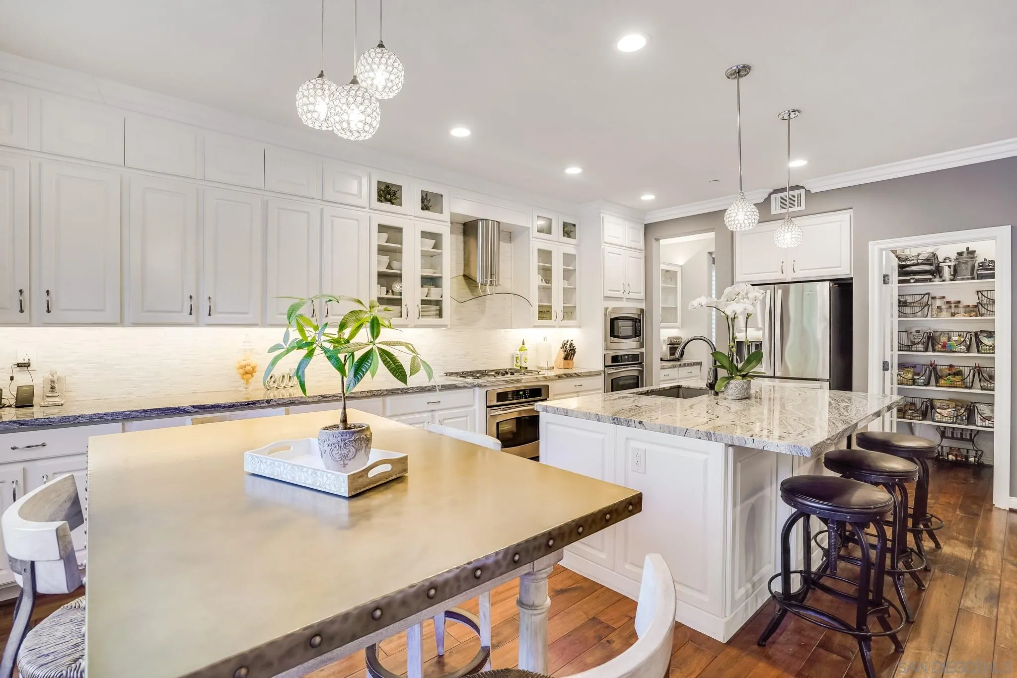 16375 Cayenne Ridge Road San Diego, CA 92127 - Photo 13 of 35 a kitchen with kitchen island granite countertop a table chairs sink and cabinets