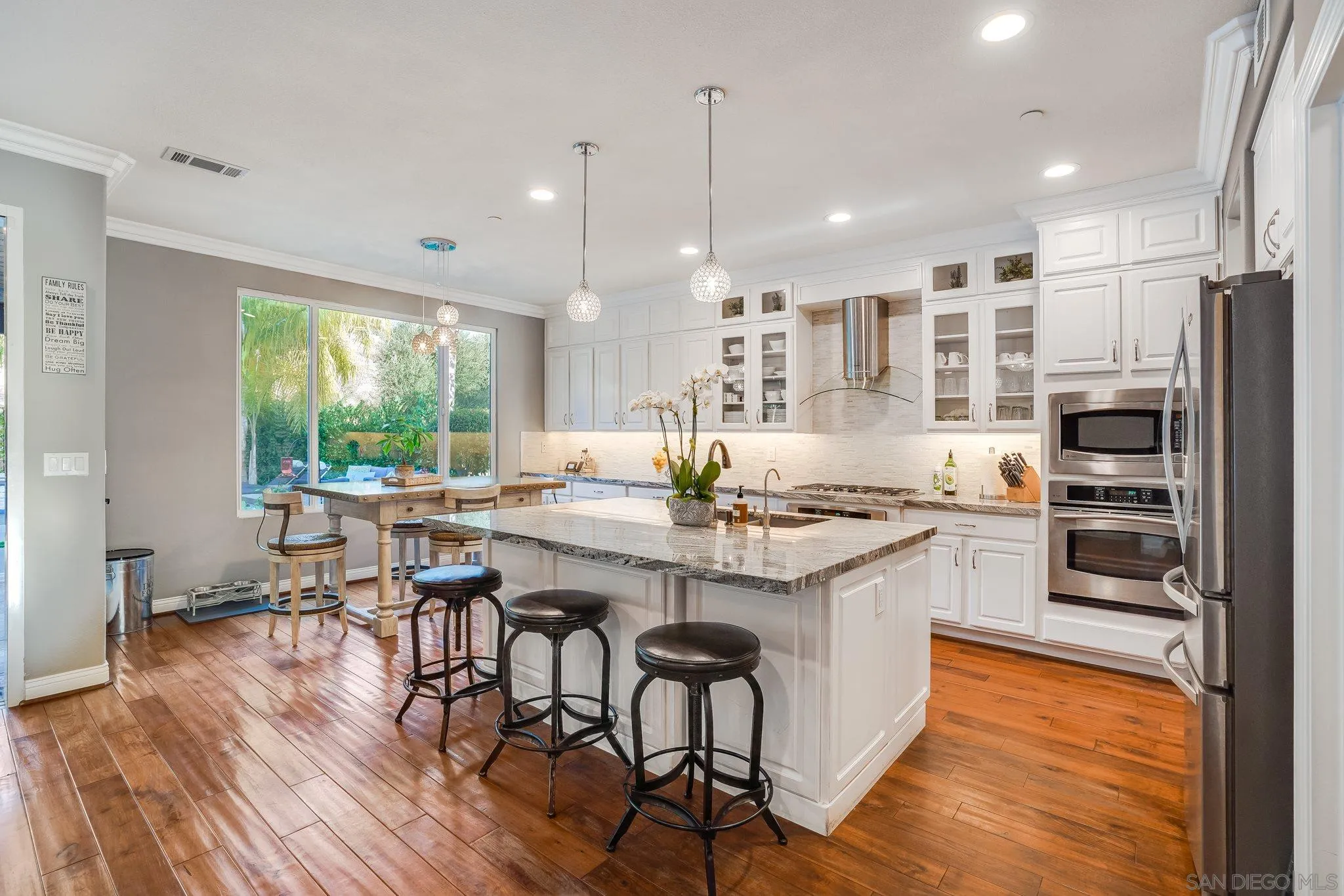 16375 Cayenne Ridge Road San Diego, CA 92127 - Photo 7 of 35 a kitchen with stainless steel appliances granite countertop a stove a refrigerator a kitchen island a stove and a wooden floors