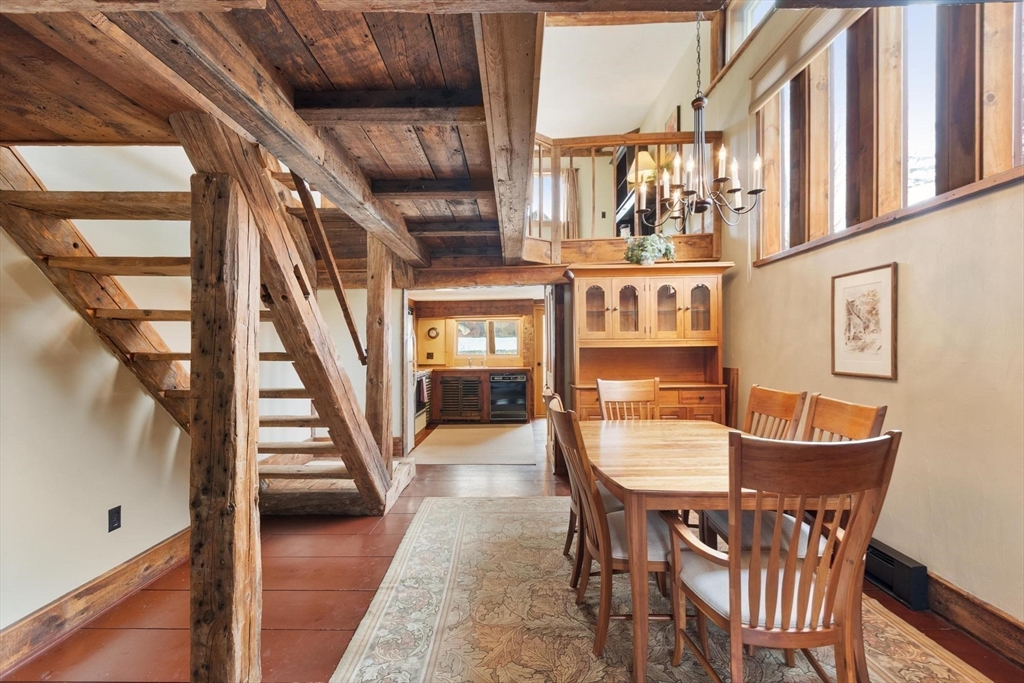 a dining room with wooden floor and furniture