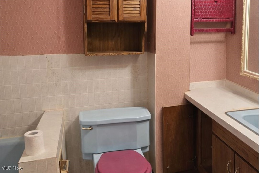 279 Coitsville Road Campbell, OH 44405 - Photo 14 of 20 Bathroom featuring wallpapered walls, a relaxing tiled tub, and vanity