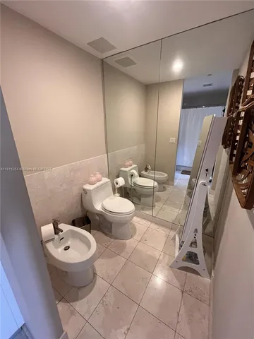 a white toilet sitting next to a bathroom sink