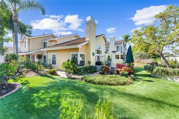 a view of a house with a big yard and potted plants