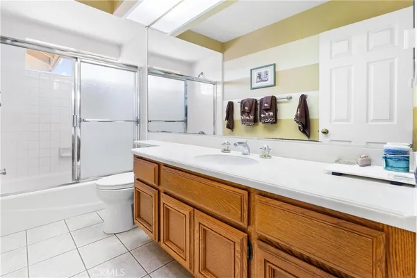a bathroom with a sink a toilet and a large mirror