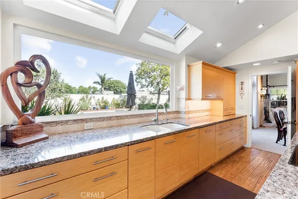 a large kitchen with granite countertop a large window and a sink