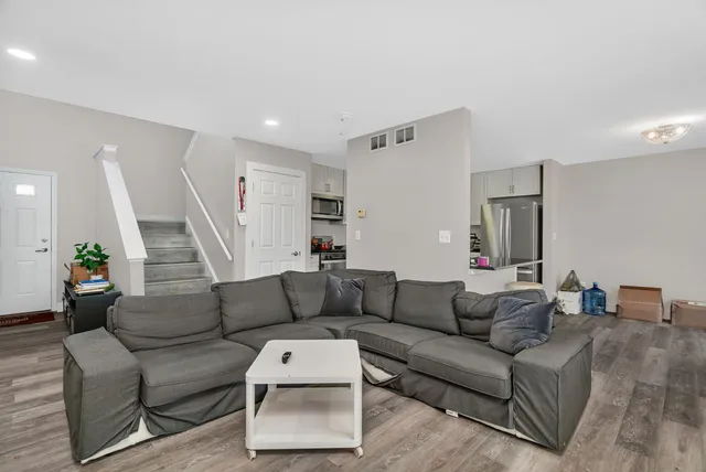 a kitchen with granite countertop white cabinets and refrigerator