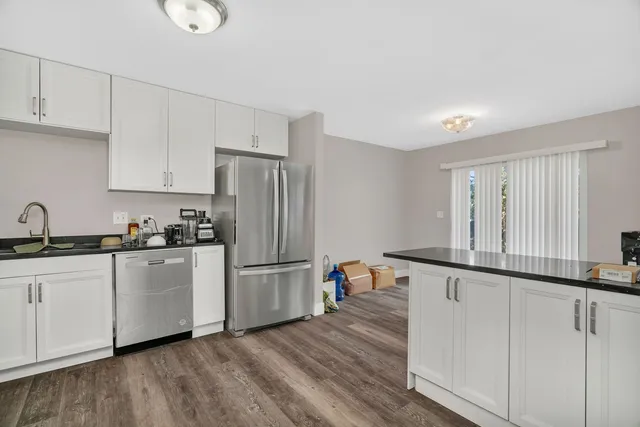 a kitchen with stainless steel appliances granite countertop a stove a white cabinets a sink and dishwasher