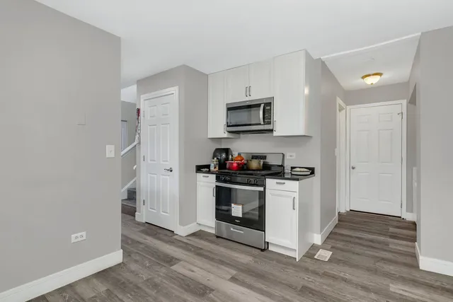 a kitchen with a wooden floor and a stove top oven