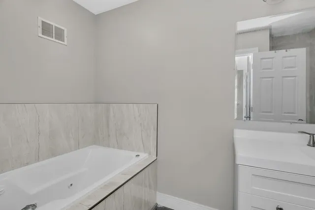 a bathroom with a sink vanity and a mirror
